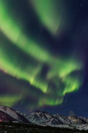 Curtains of color flood the sky over the Brooks Range in Alaska.